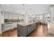 Spacious kitchen with an island, pendant lights, stainless appliances, a table, and hardwood floors at 29 Viking Dr, Cherry Hills Village, CO 80113