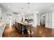 Open kitchen with an island, pendant lights, stainless appliances, cabinets, and hardwood floors at 29 Viking Dr, Cherry Hills Village, CO 80113