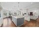 Bright kitchen with an island, pendant lights, modern appliances, hardwood floors and breakfast area at 29 Viking Dr, Cherry Hills Village, CO 80113