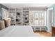 Bright main bedroom featuring custom bookshelves and a window seat beneath shuttered windows at 29 Viking Dr, Cherry Hills Village, CO 80113