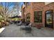 Brick home features a stone patio with comfortable lounge seating and manicured landscape at 29 Viking Dr, Cherry Hills Village, CO 80113