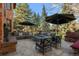 Relax on the stone patio with comfortable seating, umbrellas and outdoor dining at 29 Viking Dr, Cherry Hills Village, CO 80113