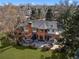 Expansive brick home featuring a spacious patio, lush lawn, mature trees, and outdoor seating area at 29 Viking Dr, Cherry Hills Village, CO 80113
