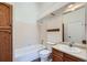 Classic bathroom featuring a tub, toilet, vanity, and wooden cabinets, exuding timeless charm at 8898 W Plymouth Ave, Littleton, CO 80128