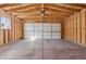 Spacious two car garage with an automatic door opener and exposed wood framing at 2408 E Cresthill Ave, Centennial, CO 80121