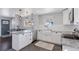 Bright kitchen boasts white cabinets, granite countertops, stainless appliances, and a large farmhouse sink at 2408 E Cresthill Ave, Centennial, CO 80121