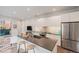 Modern kitchen features white cabinets, stainless steel appliances, and island with seating at 1300 N Ogden St # 204, Denver, CO 80218