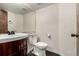 Bathroom features a vanity with a wood finish and a white sink, and a toilet at 8918 W 101St Ave, Broomfield, CO 80021
