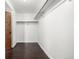 A walk-in closet featuring dark wood floors, white walls, and clothes racks at 8918 W 101St Ave, Broomfield, CO 80021