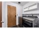 Laundry room with a wood door, a washer, a dryer, and storage shelves at 8918 W 101St Ave, Broomfield, CO 80021