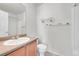 Bathroom features a shower, toilet, and vanity with a light wood cabinet and beige countertop at 18947 E 57Th Pl, Denver, CO 80249