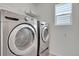 Modern laundry room featuring stainless steel washer and dryer units at 18947 E 57Th Pl, Denver, CO 80249