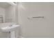 Simple powder room with pedestal sink, mirror, and chrome towel rack at 18947 E 57Th Pl, Denver, CO 80249