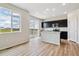 Open concept kitchen with stainless appliances, an island sink, and dark cabinets connected to a living space at 4285 Gozzer Ranch Dr, Elizabeth, CO 80107