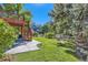 Spacious backyard with lush lawn, mature trees, deck, patio and blue house at 9261 Millcreek Ct, Highlands Ranch, CO 80126