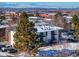 Exterior view of the condo building, with mountain views, balconies and trees nearby at 12143 Melody Dr # 104, Denver, CO 80234