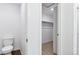 Bathroom with a partially-viewed toilet and a walk-in closet with a shelf for ample storage at 27424 E Byers Ave, Aurora, CO 80018