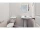 Clean and simple half-bathroom with a pedestal sink, toilet, and modern fixtures at 27424 E Byers Ave, Aurora, CO 80018