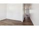 Hallway showcasing dark wood-look flooring and white walls, leading into other rooms at 27424 E Byers Ave, Aurora, CO 80018