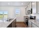 Modern kitchen with granite counters, stainless appliances, and wood floor, next to sliding doors and outdoor views at 27424 E Byers Ave, Aurora, CO 80018