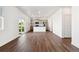 Open-concept living space with hardwood floors flowing into a kitchen with stainless appliances at 27424 E Byers Ave, Aurora, CO 80018