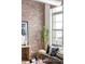 Brick wall in living room with modern decor, sofa, and large bright windows at 7700 E 29Th Ave # 411, Denver, CO 80238
