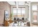 Bright living room with exposed brick wall, large windows, and stylish furnishings at 7700 E 29Th Ave # 411, Denver, CO 80238