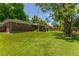 Expansive backyard with a lush lawn, a covered patio, mature trees, and a privacy fence, providing ample space at 1410 S Ammons St, Lakewood, CO 80232