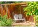 Secluded backyard nook with a cozy bench, framed by lush greenery and a wooden fence, creating a peaceful hideaway at 1410 S Ammons St, Lakewood, CO 80232