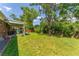 Lush backyard features a well-manicured lawn, a covered patio, and mature trees, creating a serene outdoor oasis at 1410 S Ammons St, Lakewood, CO 80232