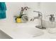 Bathroom vanity featuring a white countertop, modern faucet, and a decorative orchid at 1410 S Ammons St, Lakewood, CO 80232