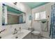 Bathroom showcasing vanity, toilet, and a blue-tiled decorative mirror at 1410 S Ammons St, Lakewood, CO 80232
