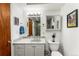 Bright bathroom with a stylish vanity, decorative mirror, and framed artwork at 1410 S Ammons St, Lakewood, CO 80232