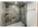 Modern shower with glass door, tile surround, and rainfall shower head at 1410 S Ammons St, Lakewood, CO 80232