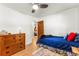 Small bedroom featuring hardwood floors and a dresser with a peek into the other room at 1410 S Ammons St, Lakewood, CO 80232