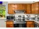 The modern kitchen includes updated appliances, stainless steel hood, microwave, and wood cabinets at 1410 S Ammons St, Lakewood, CO 80232