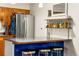 Features a kitchen island with chrome stools and decorative shelving at 1410 S Ammons St, Lakewood, CO 80232