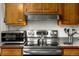 The modern kitchen includes updated appliances, stainless steel hood, microwave, and wood cabinets at 1410 S Ammons St, Lakewood, CO 80232