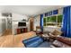 Bright living room with hardwood floors, large windows, and comfortable seating area at 1410 S Ammons St, Lakewood, CO 80232