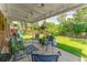 Relaxing covered patio with outdoor seating overlooks the spacious, lush backyard, perfect for entertaining guests at 1410 S Ammons St, Lakewood, CO 80232