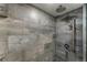 Modern shower featuring stylish tile, rainfall showerhead, and handheld sprayer at 1410 S Ammons St, Lakewood, CO 80232