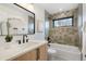 Bathroom with a tub-shower combo, stylish vanity, modern fixtures, and natural light at 3047 S Cherokee St, Englewood, CO 80110