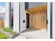 Close up of home's modern doorway with wooden accent, and stylish black door with house numbers at 3047 S Cherokee St, Englewood, CO 80110