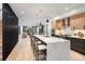Open-concept kitchen with quartz island, pendant lighting, and hardwood floors with a full living space view at 3047 S Cherokee St, Englewood, CO 80110