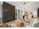 Open-concept living room featuring a stone fireplace, modern furnishings, dining area and hardwood floors at 3047 S Cherokee St, Englewood, CO 80110