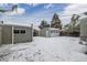 Large backyard showcasing the detached garage and snow covered yard at 118 S Dale Ct, Denver, CO 80219