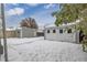 View of the backyard with snow-covered ground and detached garage, creating a serene winter scene at 118 S Dale Ct, Denver, CO 80219