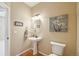 Charming half bath with pedestal sink, stylish artwork, and hardwood floors at 10572 Jaguar Gln, Lone Tree, CO 80124
