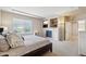 Bright bedroom with large window, tiled fireplace, and neutral colors; creates a relaxing and inviting atmosphere at 10572 Jaguar Gln, Lone Tree, CO 80124