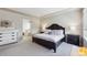 Spacious primary bedroom with a large dark-wood bed, neutral decor, and carpet; offers a luxurious and comfortable retreat at 10572 Jaguar Gln, Lone Tree, CO 80124